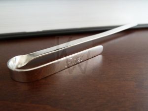 Marcapágina de diseño moderno y líneas limpias realizado en Plata de Ley 925; la pieza presenta una superficie plana con terminación pulida de alto brillo que sobresale del libro, permitiendo la personalización mediante el grabado de un nombre. Un accesorio de escritorio elegante que destaca por su estética minimalista y su acabado impecable.