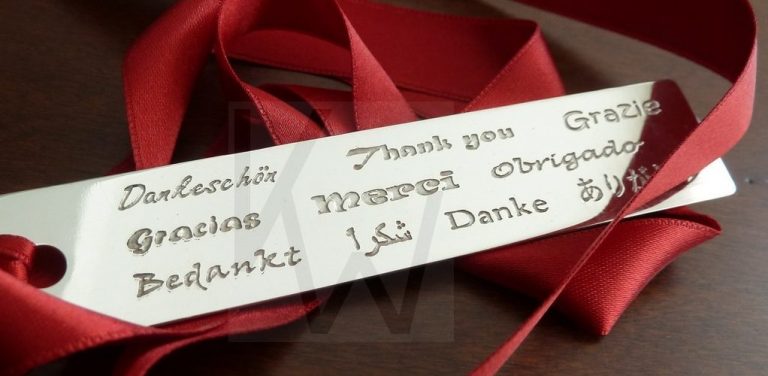 Marcapáginas artesanal de plata grabado con la palabra "Gracias" en diferentes idiomas, simbolizando la filosofía de gratitud y el alcance internacional de mi joyería de autor.