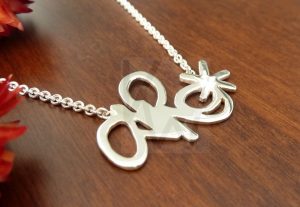 Collar artesanal realizado en Plata de Ley 925 compuesto por una cadena de la que pende un motivo personalizado soldado de forma permanente; el diseño mostrado presenta una forma abstracta con una terminación pulida de alto brillo, ofreciendo la posibilidad de convertir cualquier boceto o concepto propio en una joya de autor totalmente exclusiva.