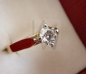 Anillo solitario de diseño clásico realizado en oro de 18k, con un diamante central engastado mediante cuatro garras que elevan la piedra para maximizar su entrada de luz y brillo.